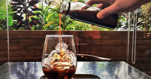 Pouring coffee over ice to make iced coffee.