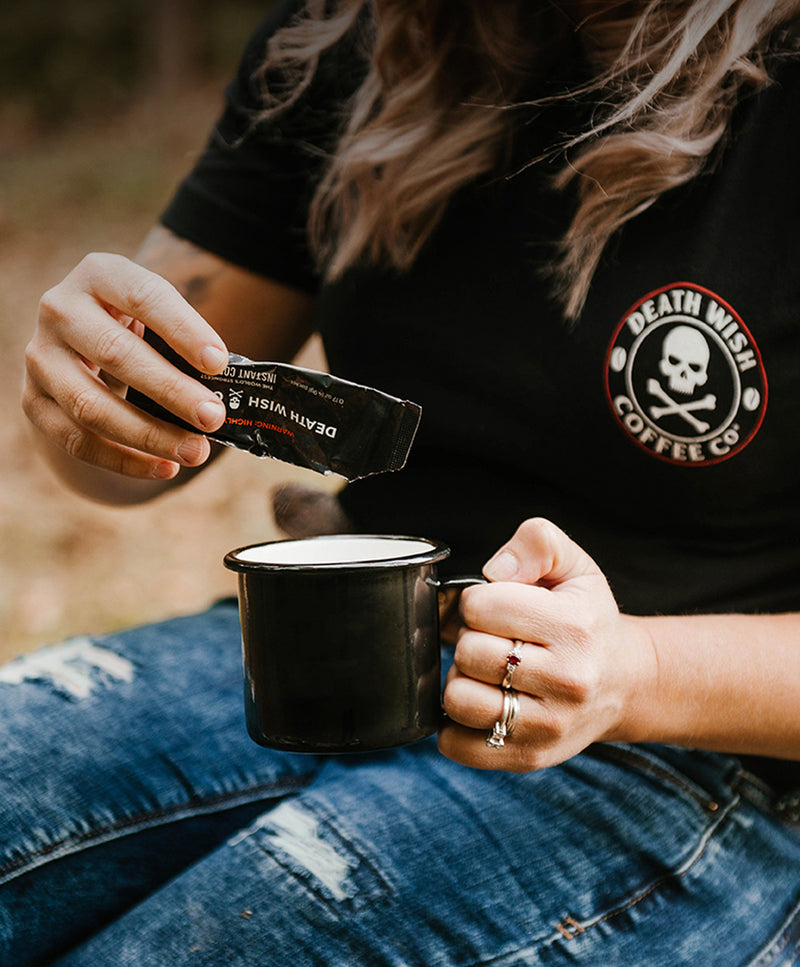 Pouring Death Wish Coffee Instant Dark Roast Coffee into a mug.